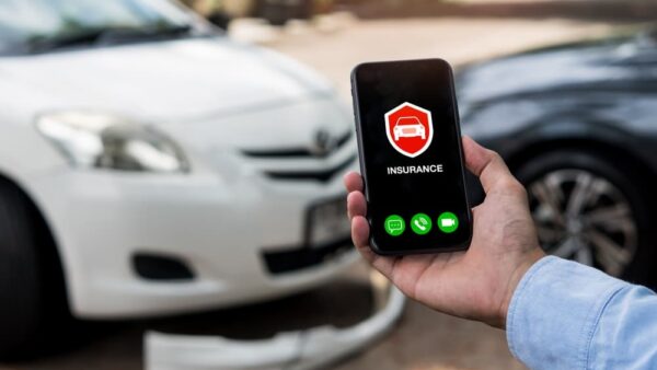 Man using phone to calling insurance agent for claim process after car crash.