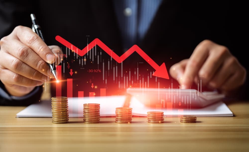 Conceptual image of economic collapse: a businessman stands next to a falling financial graph chart, symbolizing the impact of a global recession.