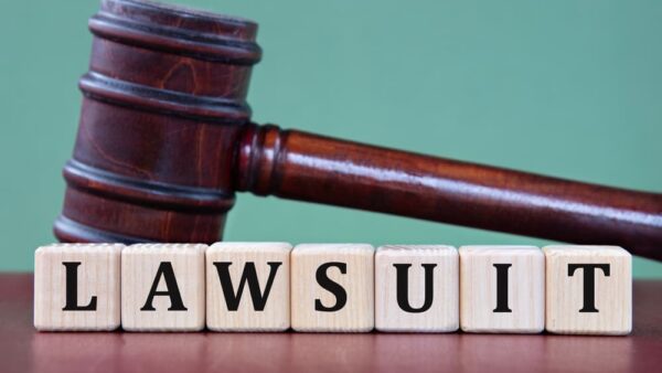 LAWSUIT - word on wooden cubes on background of judge's gavel.