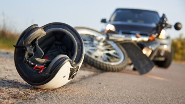 Photo of car, helmet and motorcycle on road, the concept of road accidents.