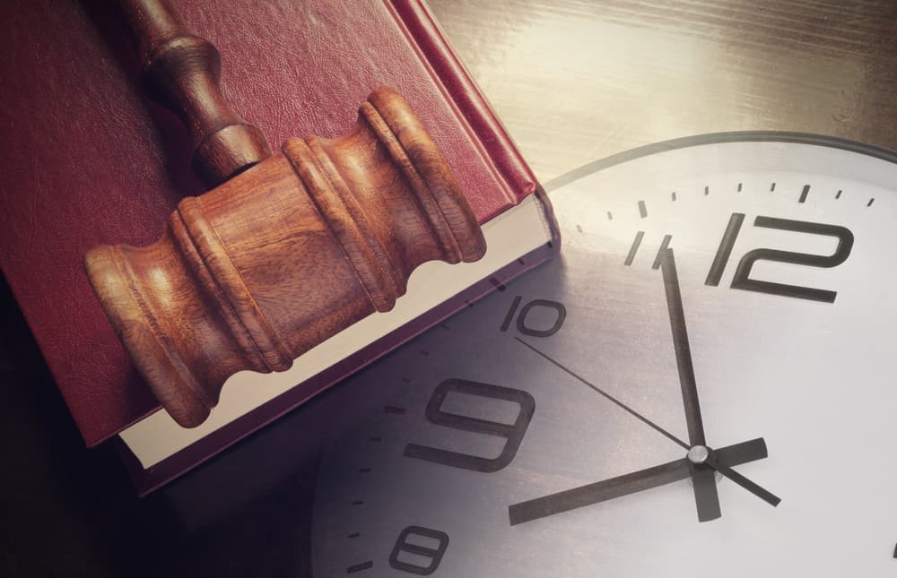 A wall clock with attorney hammer and book