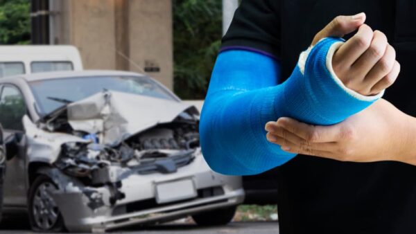 Close up man holding hand with blue bandage as arm injury concept with car accident