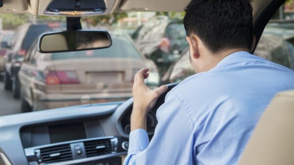 Rear view of furious young man driving a car on the road at the traffic jam