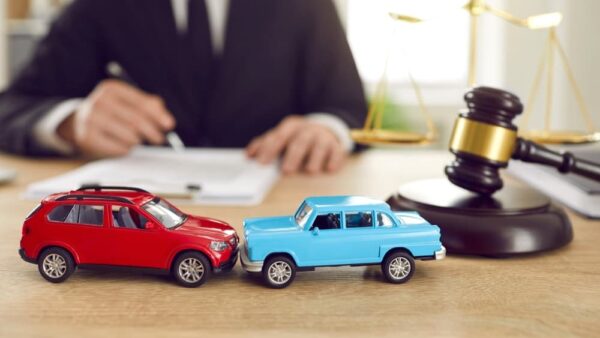 Miniature cars and judge gavel on desk of lawyer