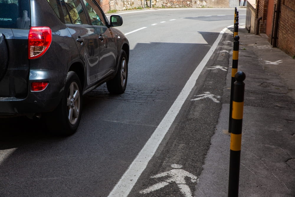 Car encroaching on a marked pedestrian walkway in San Jose, illustrating a dangerous road condition that may support a government tort claim against the City