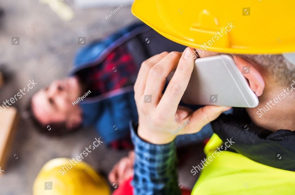 Worker giving first aid to unconscious colleague after accident, highlighting legal rights and workplace safety issues.