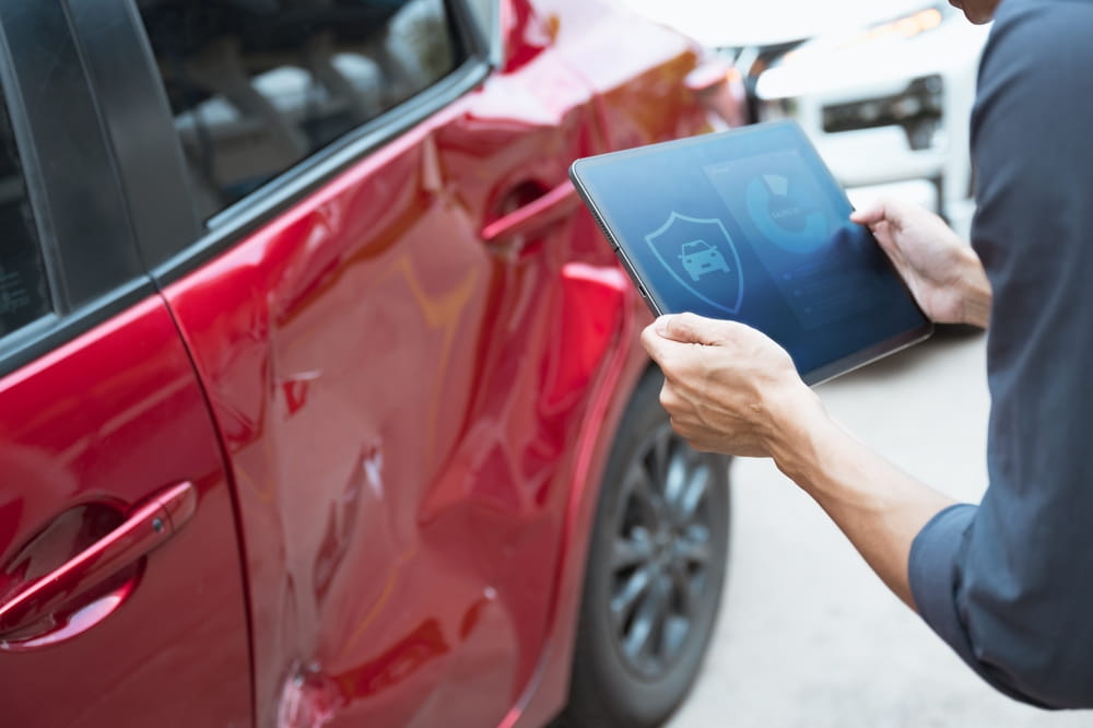 Insurance adjuster inspecting vehicle damage after accident