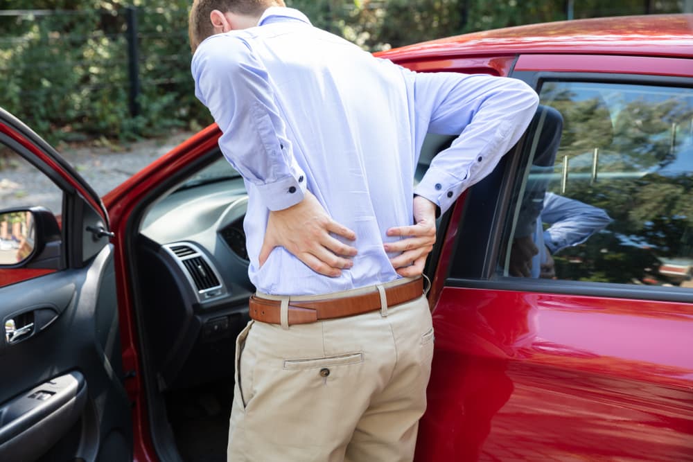 The car driver standing having backpain after driving car.