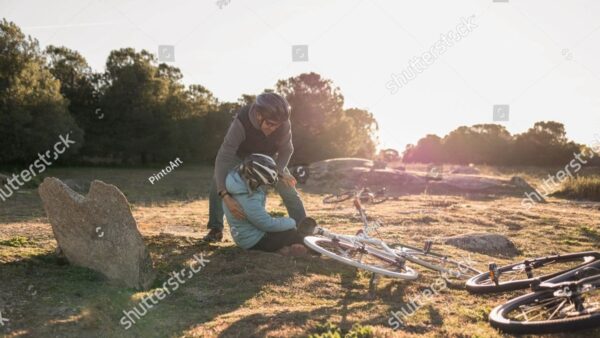 Cyclist helping injured friend after crash on private land, highlighting injury risks and liability in outdoor spaces.