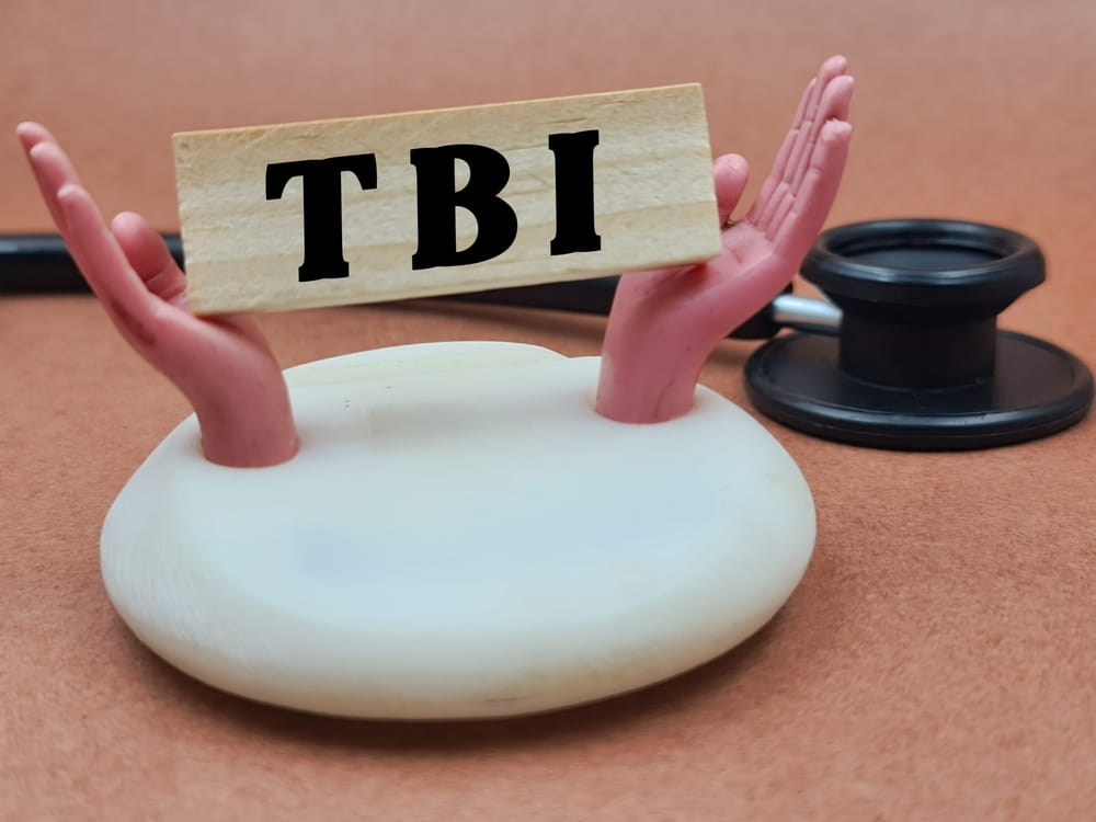 Hands holding TBI block symbolizing legal support in a brain injury claim