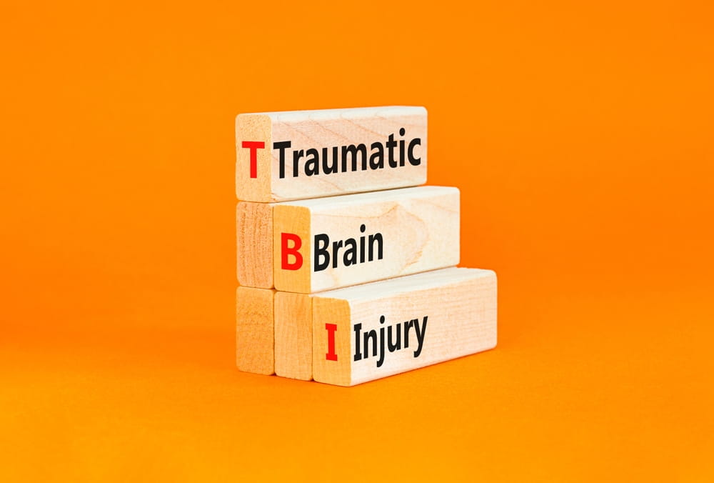 Wooden blocks spelling TBI for traumatic brain injury legal claim concept