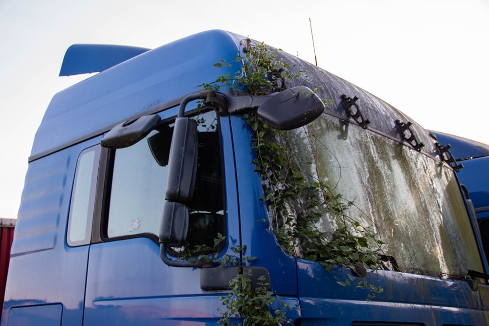 Abandoned commercial truck cab overgrown with vegetation, representing the risk of black box data being lost or overwritten after a San Jose truck accident